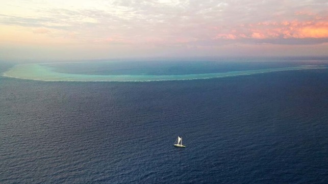 The sailboat is located on the approximate position of a proposed well site, with North Scott Reef in the background (Greenpeace)