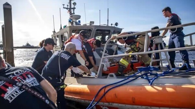 Coastguardsmen and first responders transfer the victim ashore at Mayport (Jacksonville Fire Rescue Department)